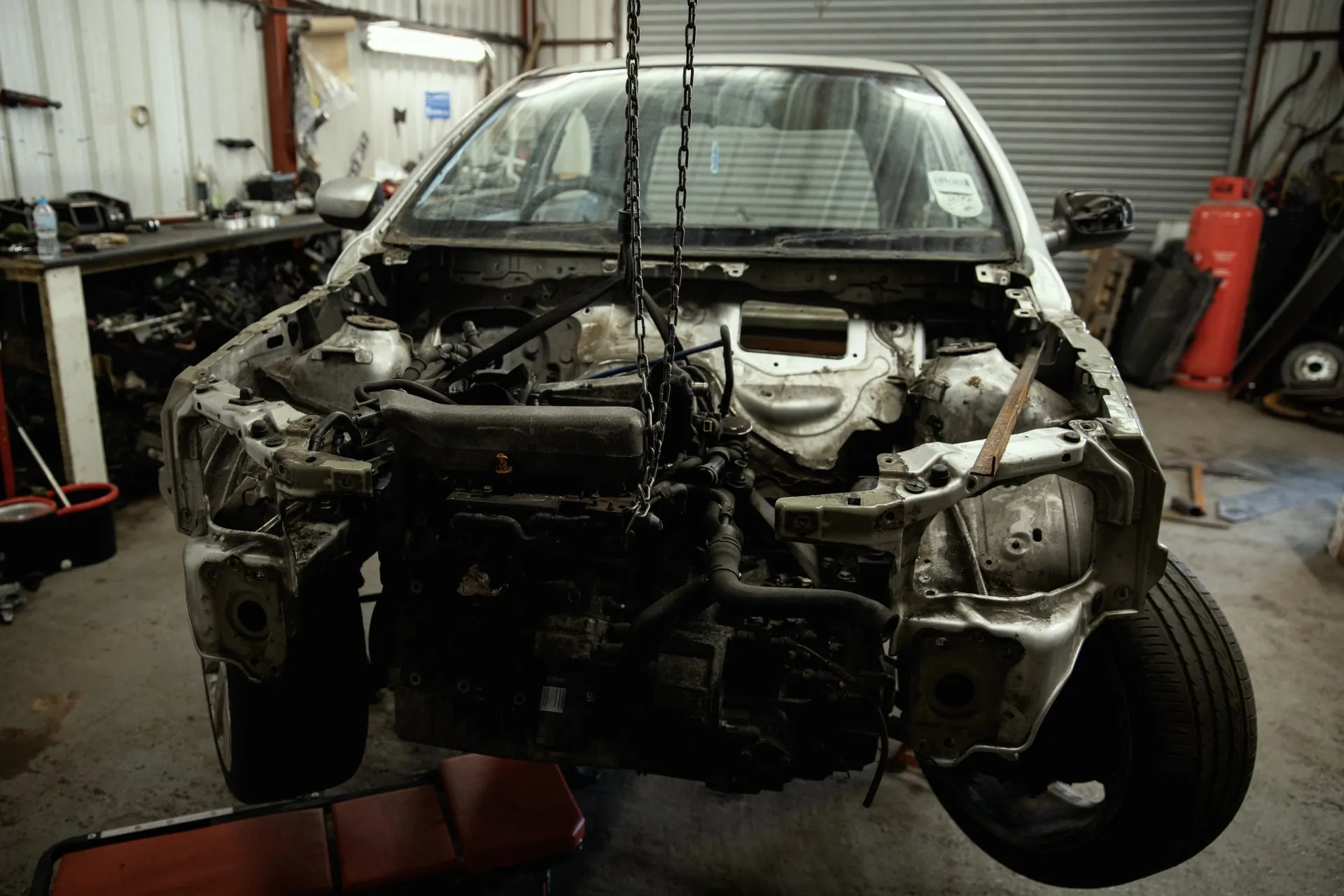 Engine suspended on chain hoist during removal