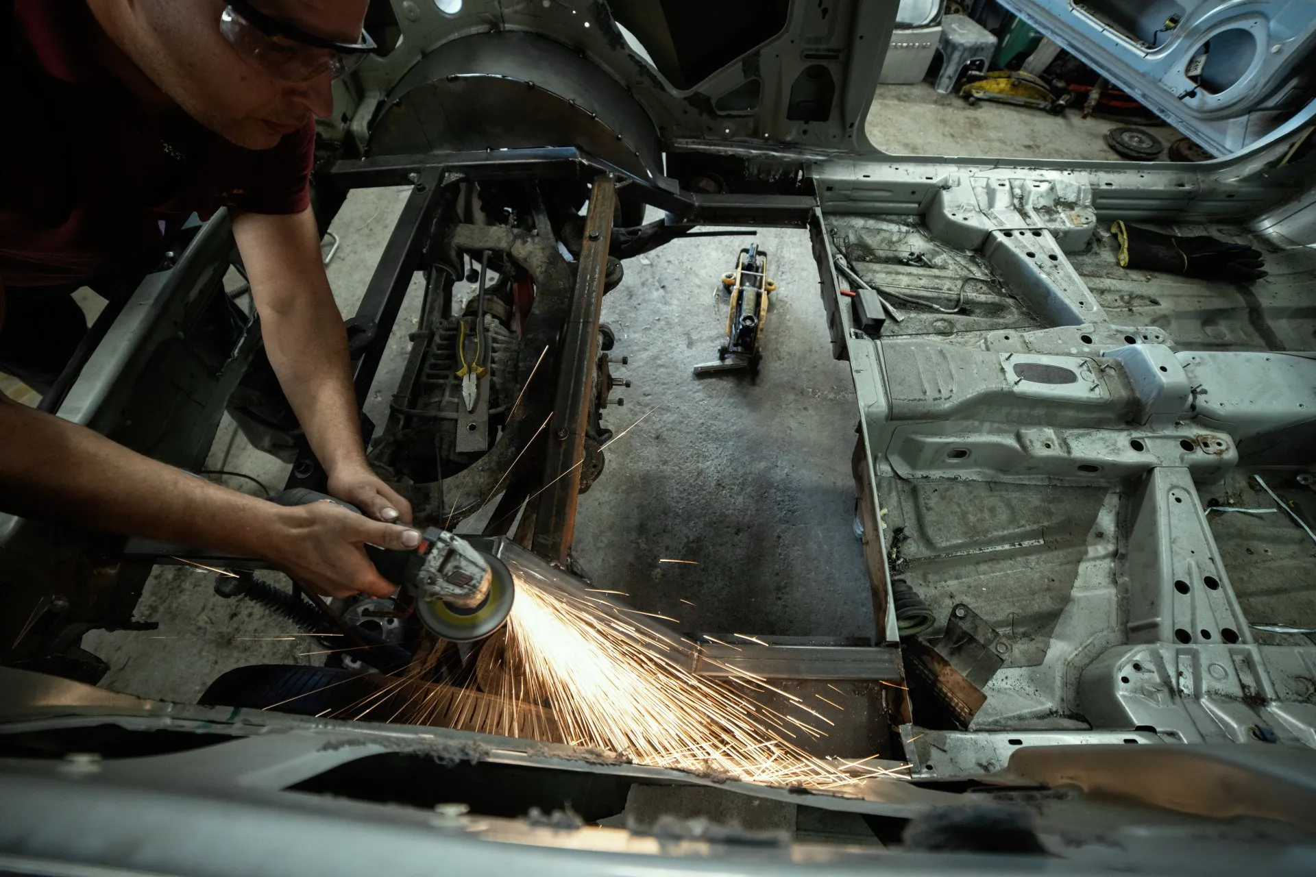 Overhead view of chassis grinding with heavy sparks
