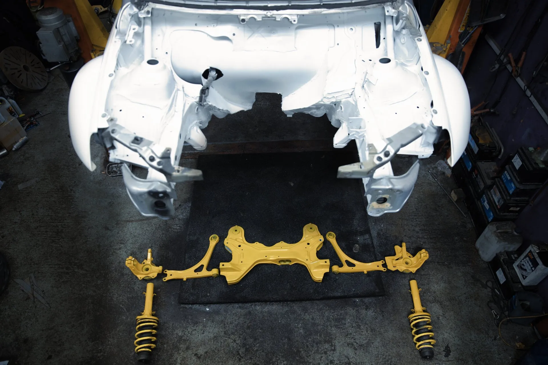Freshly painted shell with yellow subframe and suspension components laid out