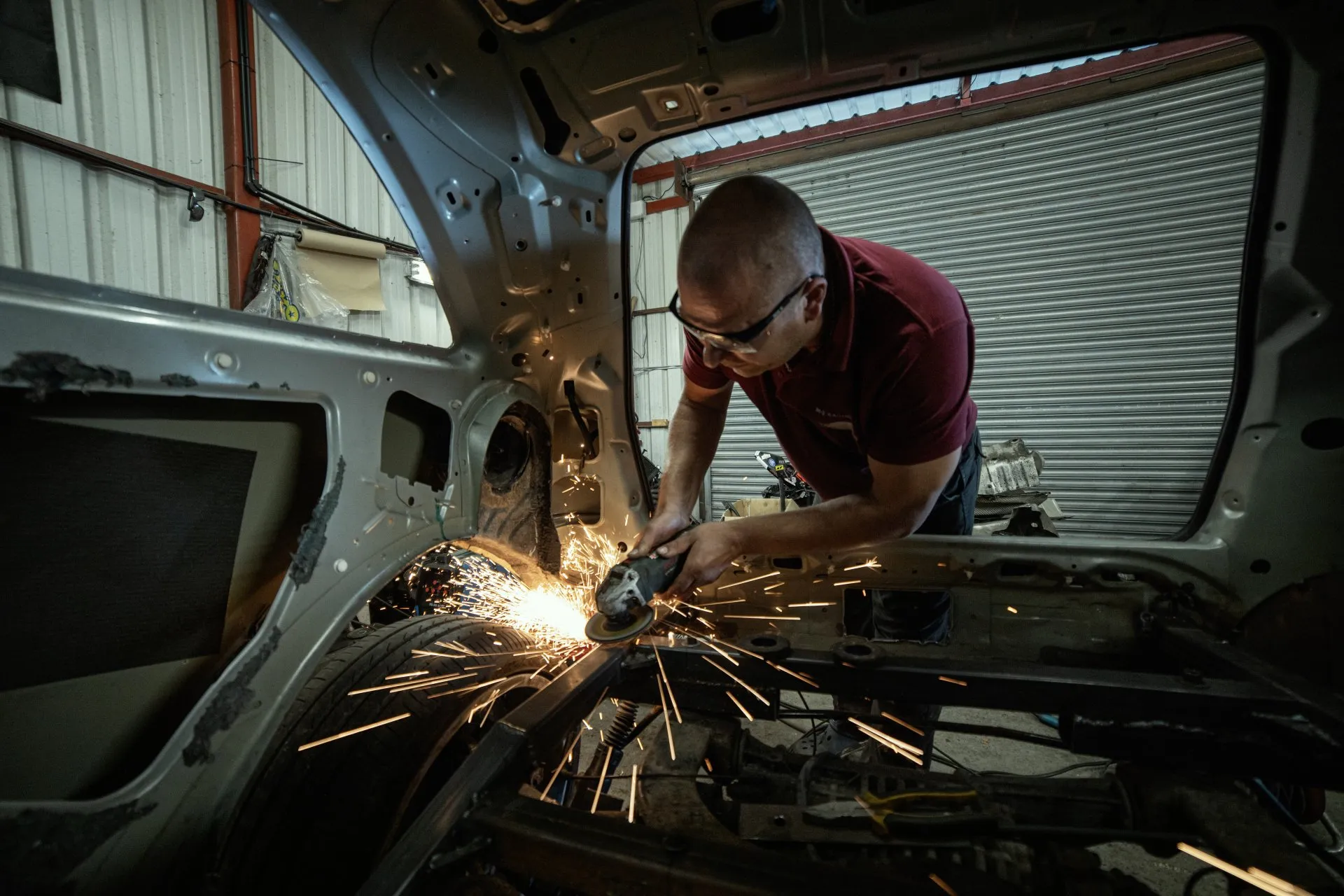 Mechanic grinding welds with sparks flying