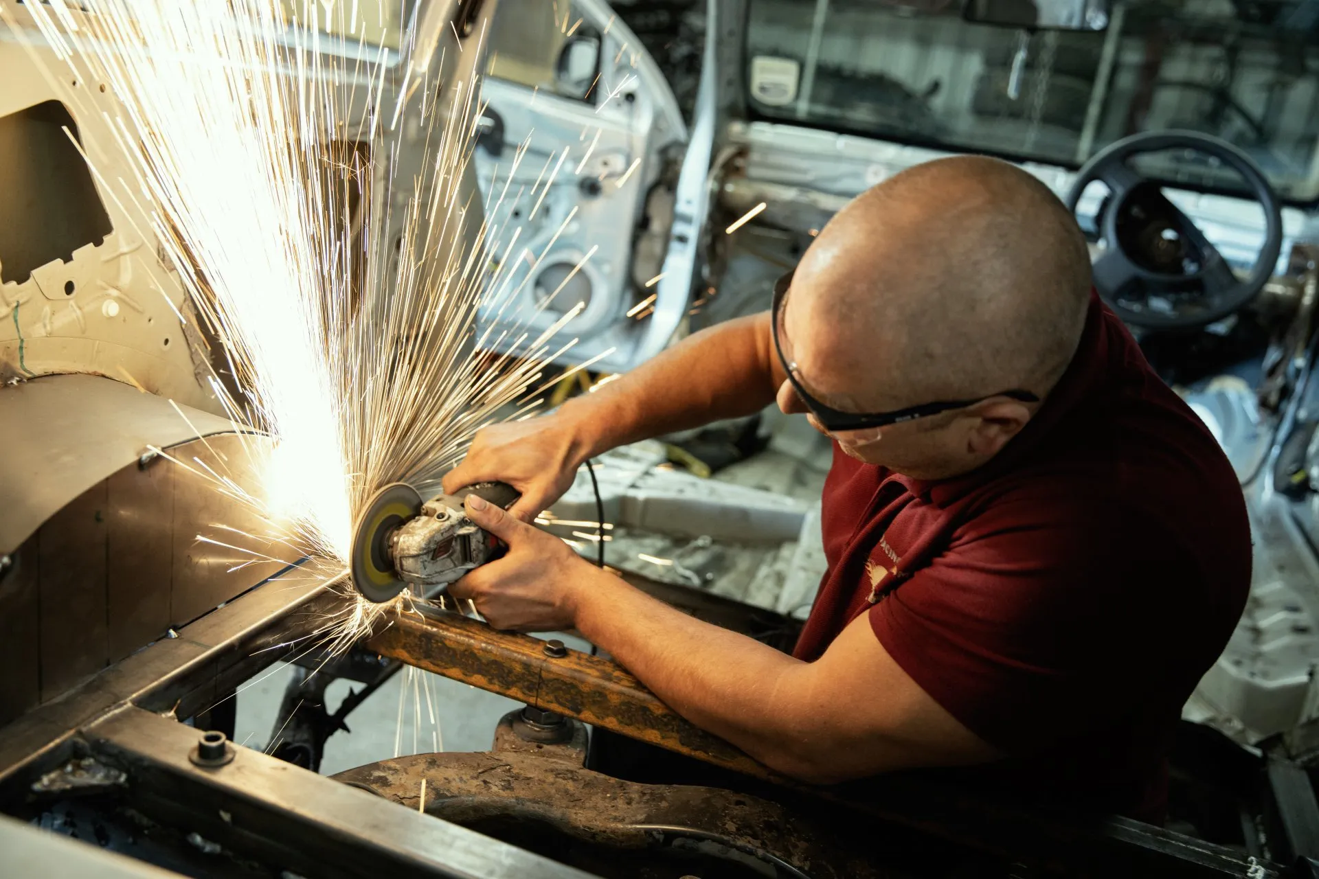Close-up of angle grinder shaping chassis metal