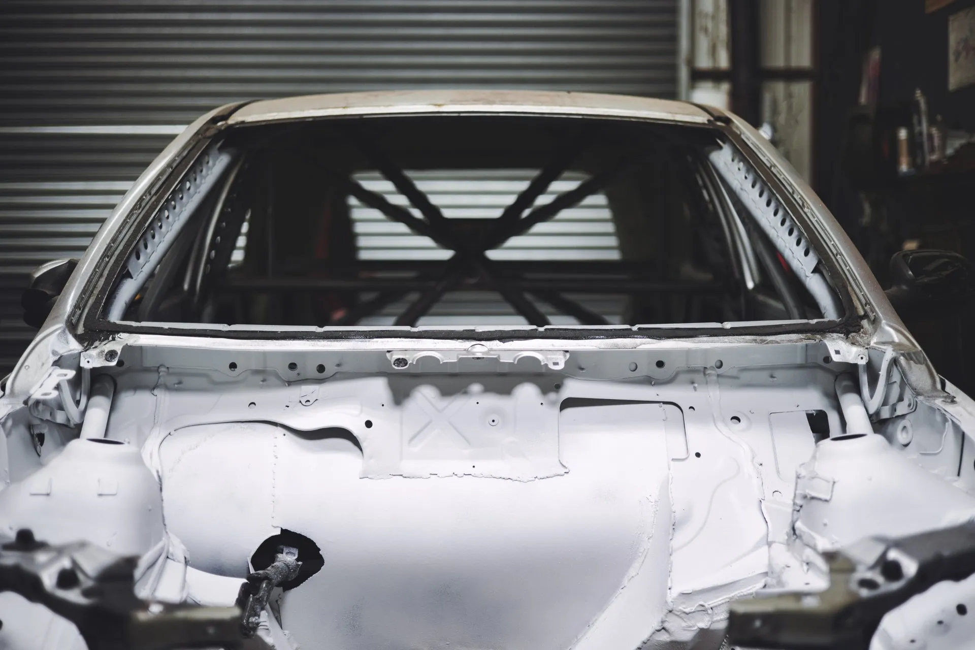 Stripped bodyshell with roll cage inside workshop