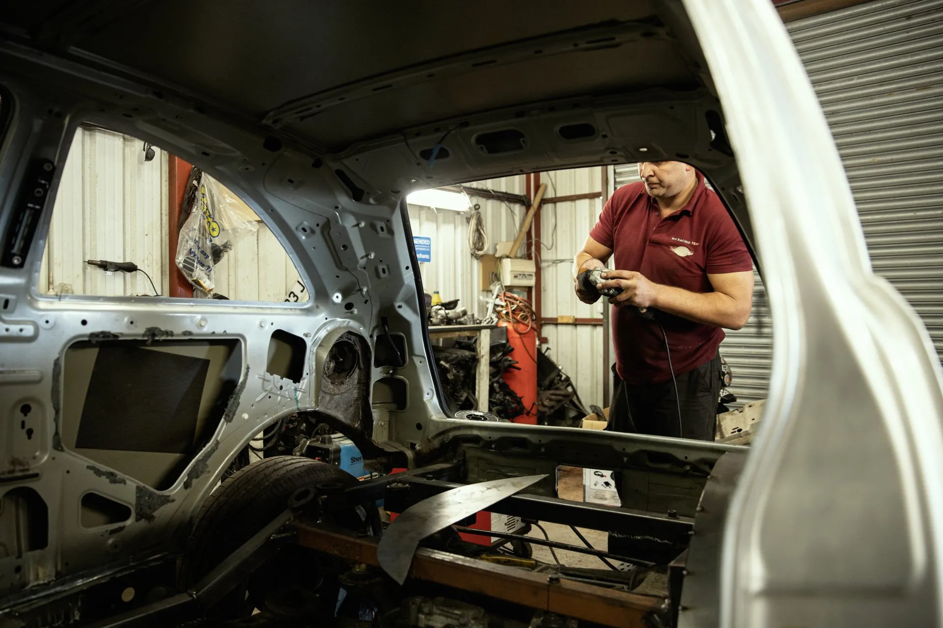 Mechanic prepping bodyshell inside the workshop